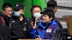 Chinese security personnel gather to remove Chinese journalists from the scene of an explosion in Sanhe city in northern China's Hebei province, March 13, 2024.