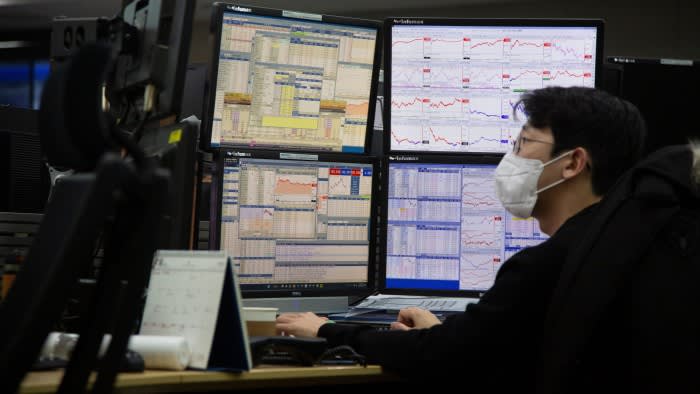 A South Korean dealer works in front of monitors