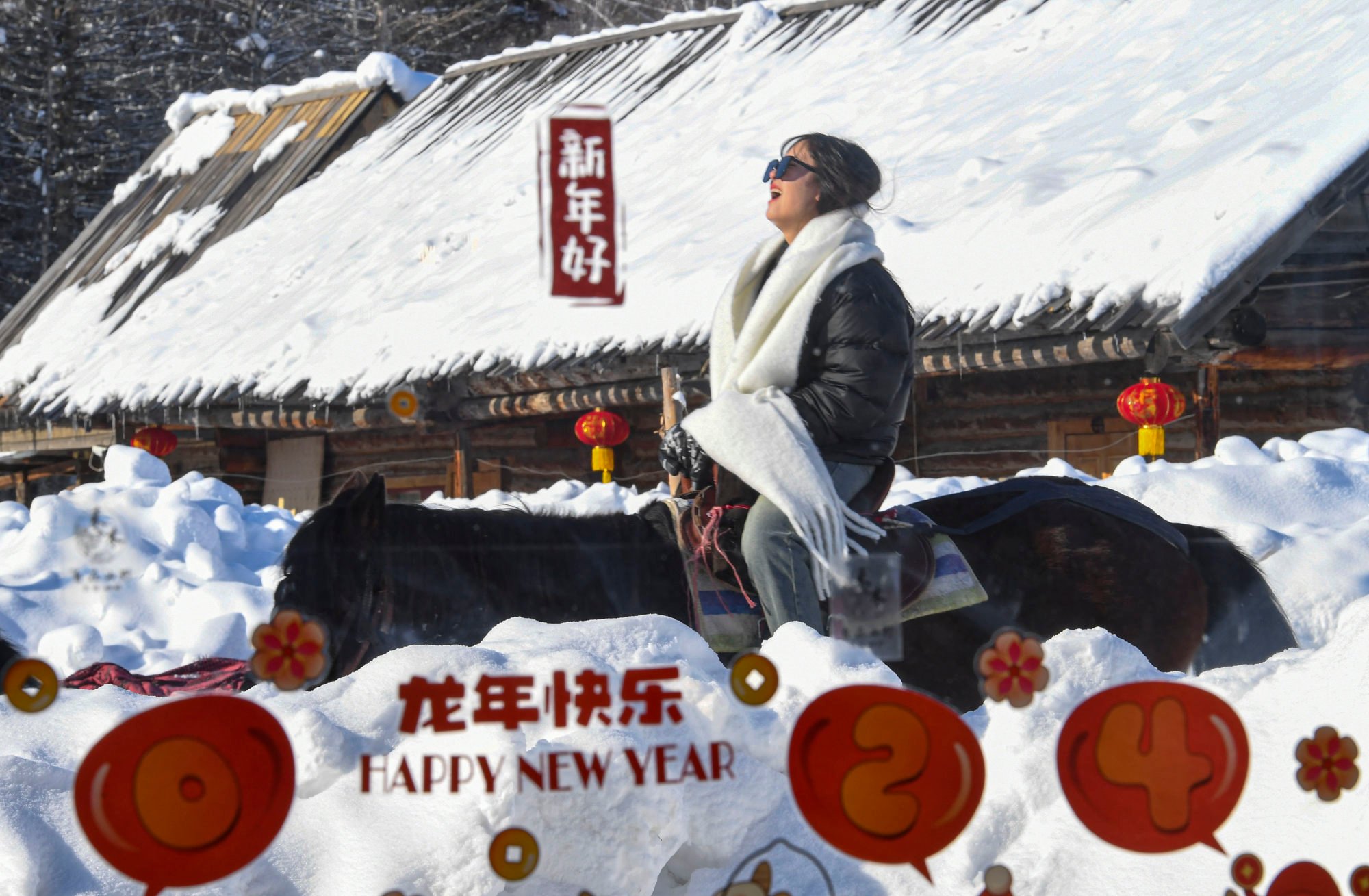 A tourist riding a horse passes a coffee shop in Hemu Village in Altay Prefecture in Xinjiang. China is promoting tourism in the region. Photo: Xinhua