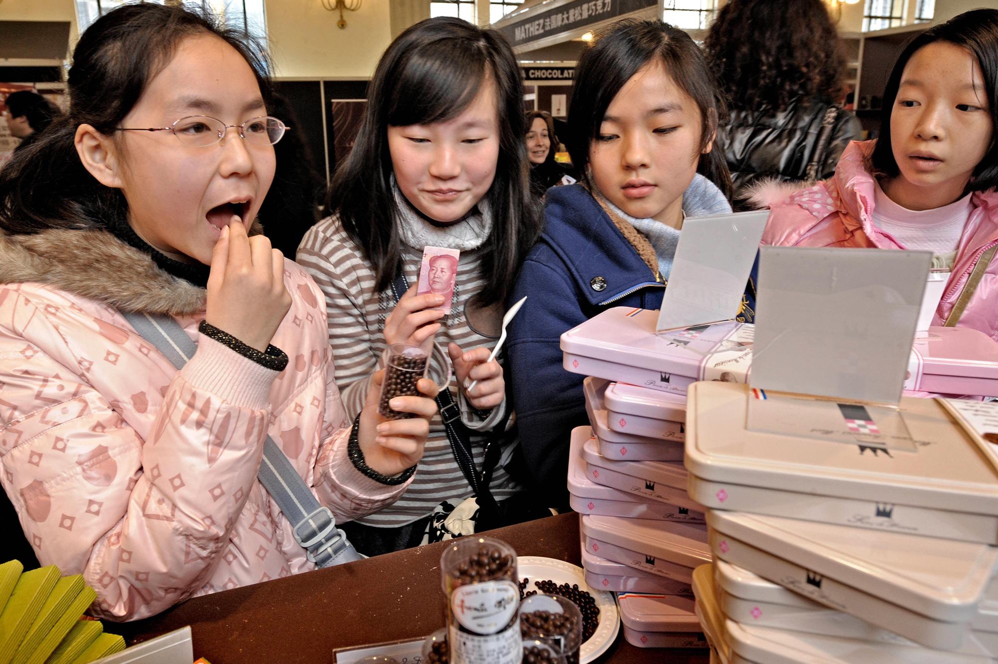 Chinese children taste chocolate before buying at a stall of the Salon du Chocolat, a chocolate fair, in Shanghai on January 21, 2010. Photo: AFP