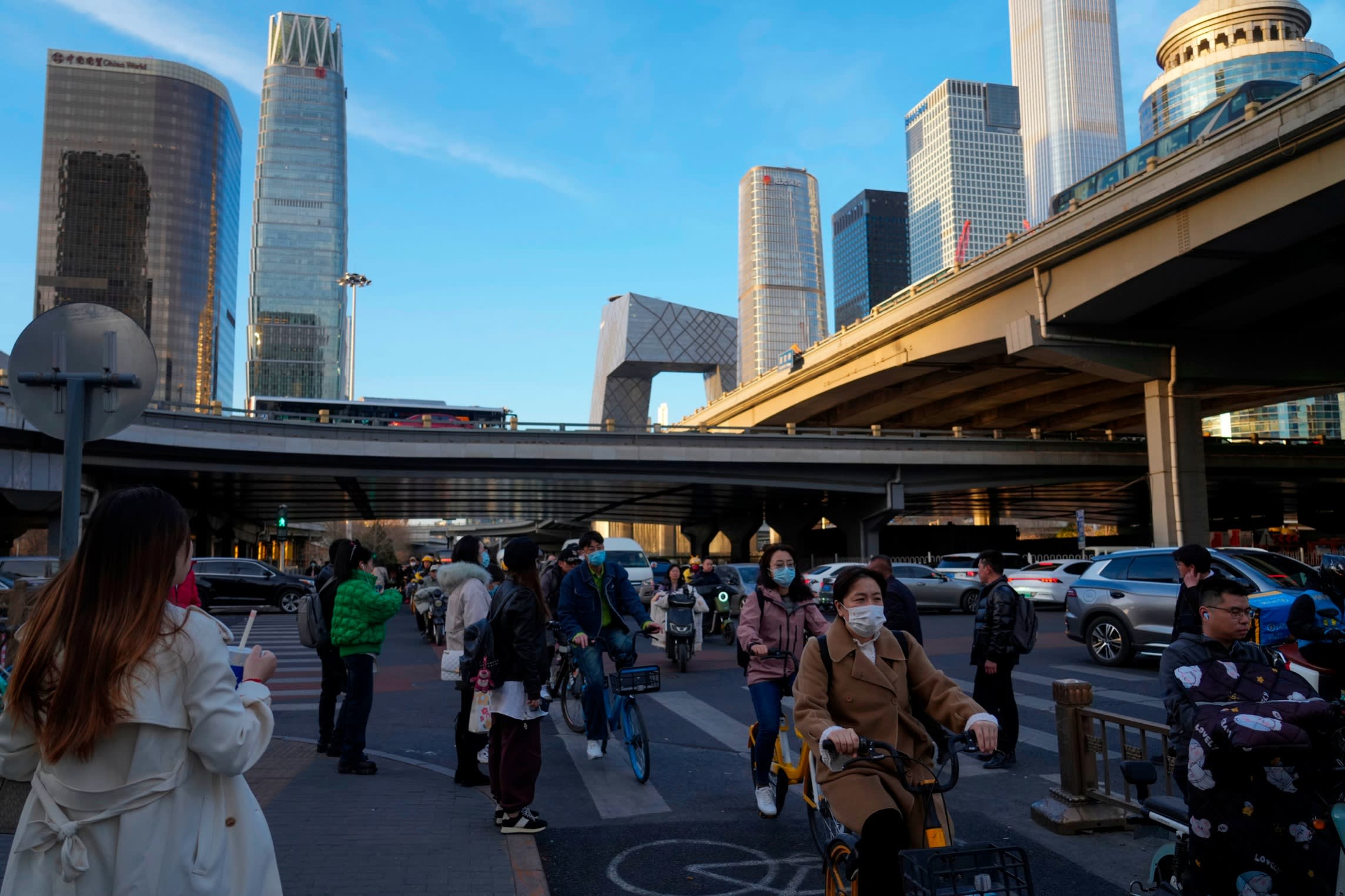 Cyclists pass through the central business district of Beijing. China’s economic planners say they are trying to avoid repeating the same mistakes that led to the crippling debts linked to property and infrastructure development