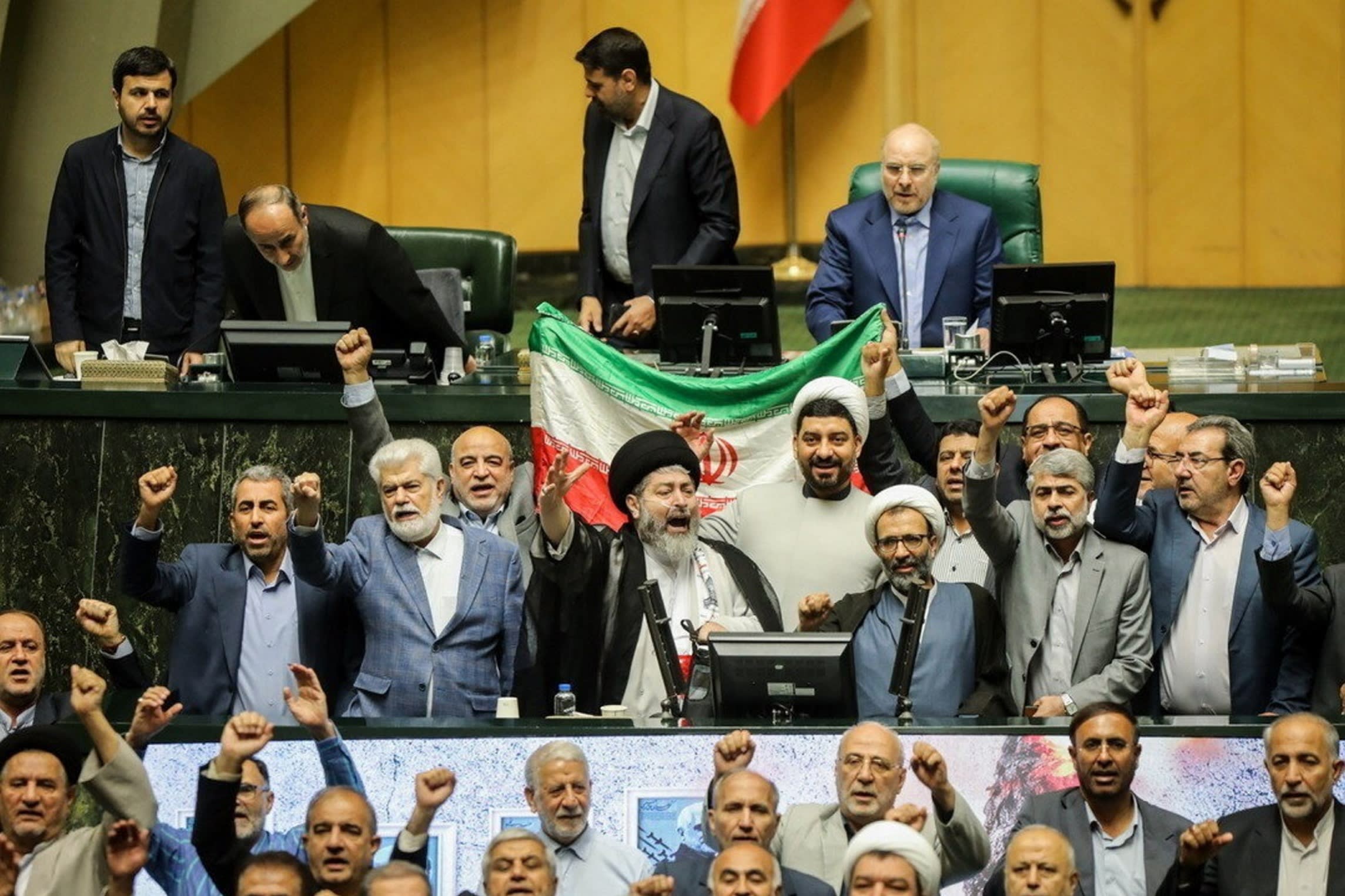 Iranian lawmakers chant slogans at an open session of the parliament in Tehran