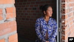 Chhem Hay, 37, stands at a main door of her house under construction at Run Ta Ek village in Siem Reap province, Cambodia, on April 2, 2024.