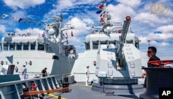 In this photo released by the official Facebook page of the Ream Naval Base, Cambodian navy crew stand on a patrol boat at the Ream Naval Base in Sihanoukville, southwest of Phnom Penh, Dec. 3, 2023.