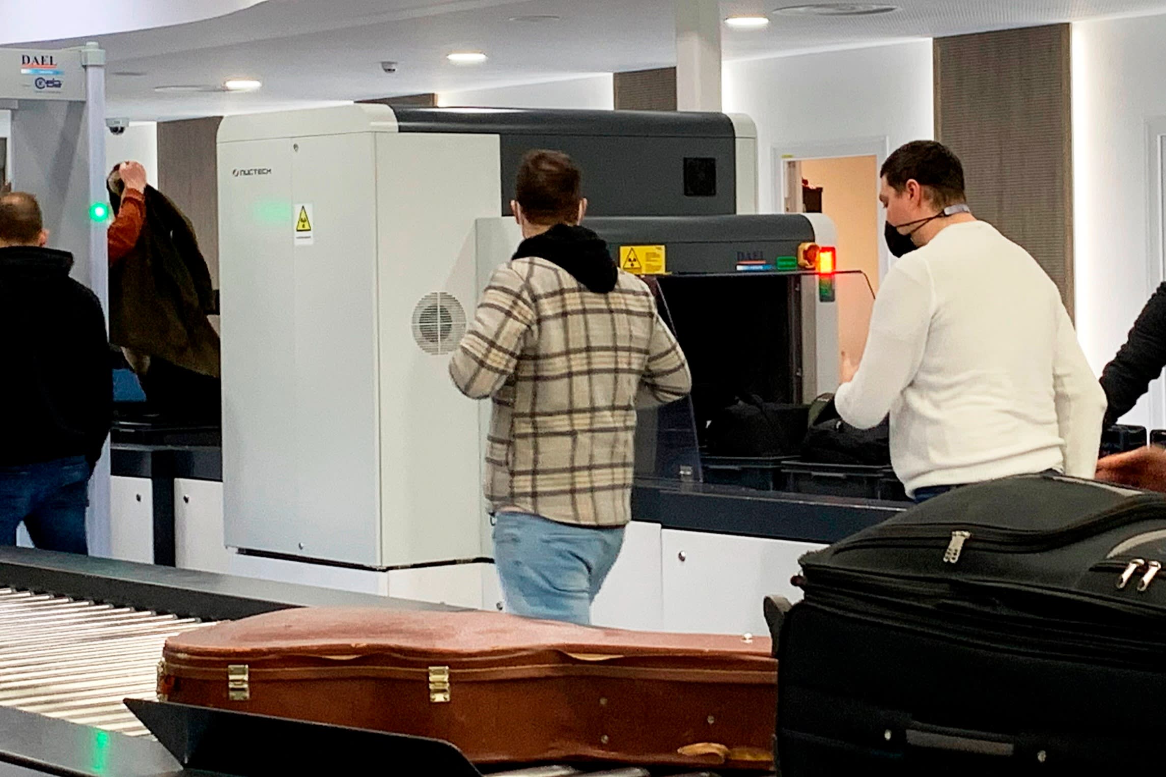 Passengers walk next to Nuctech security scanners at the Brussels Eurostar train terminal