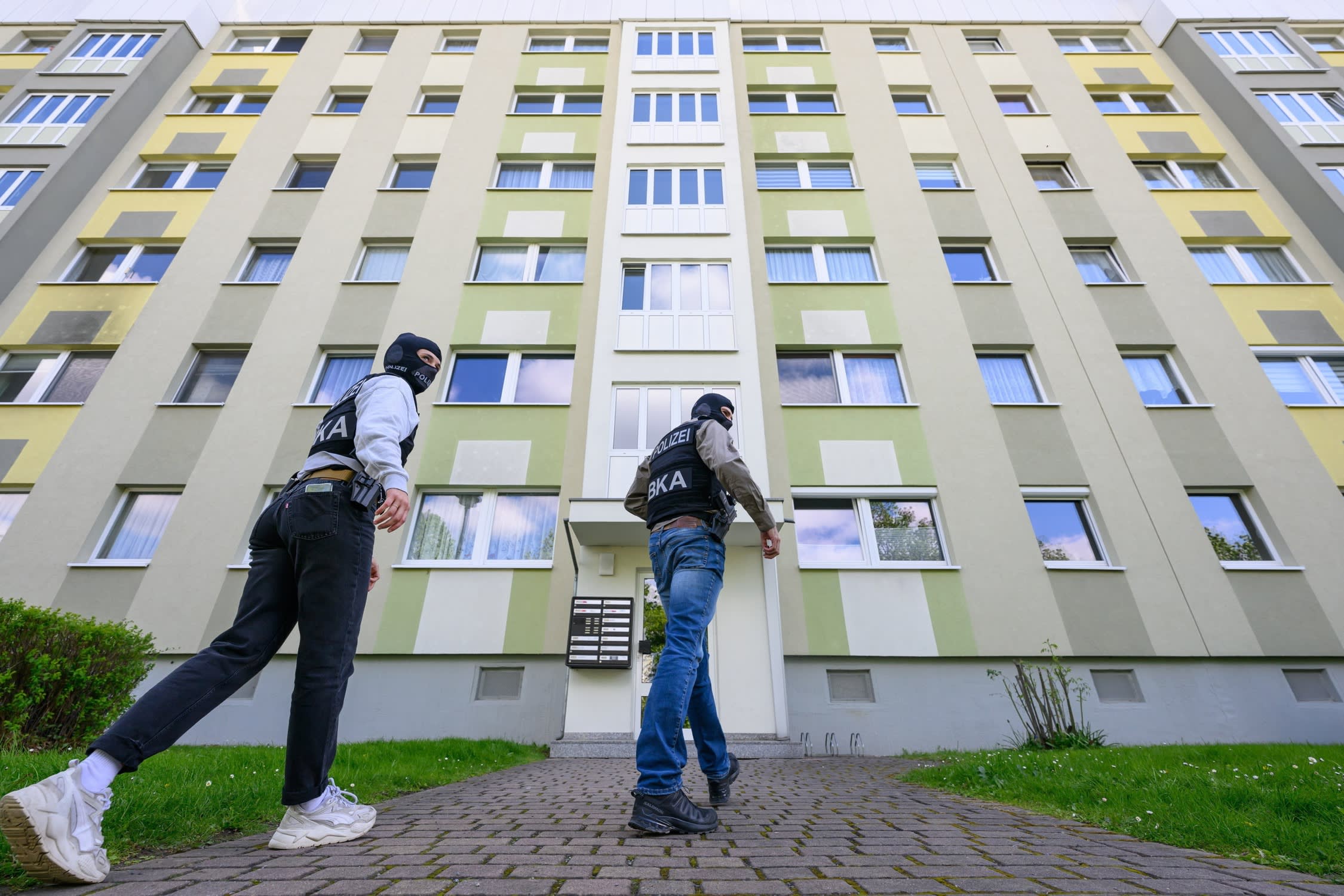 Police officers from the Federal Criminal Police Office enter an apartment building for a search