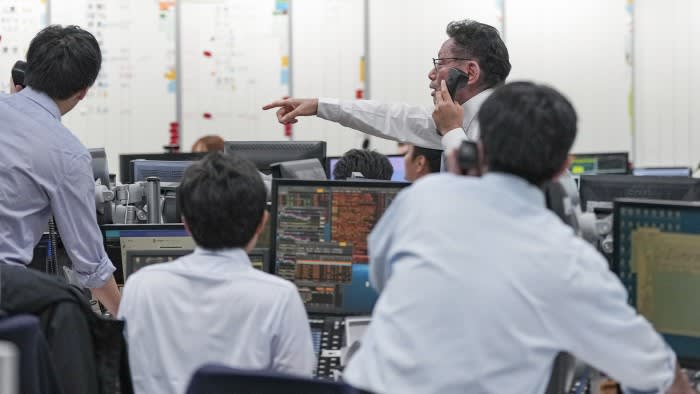 Call loan brokers at work on the trading floor of brokerage Tokyo Tanshi in Tokyo
