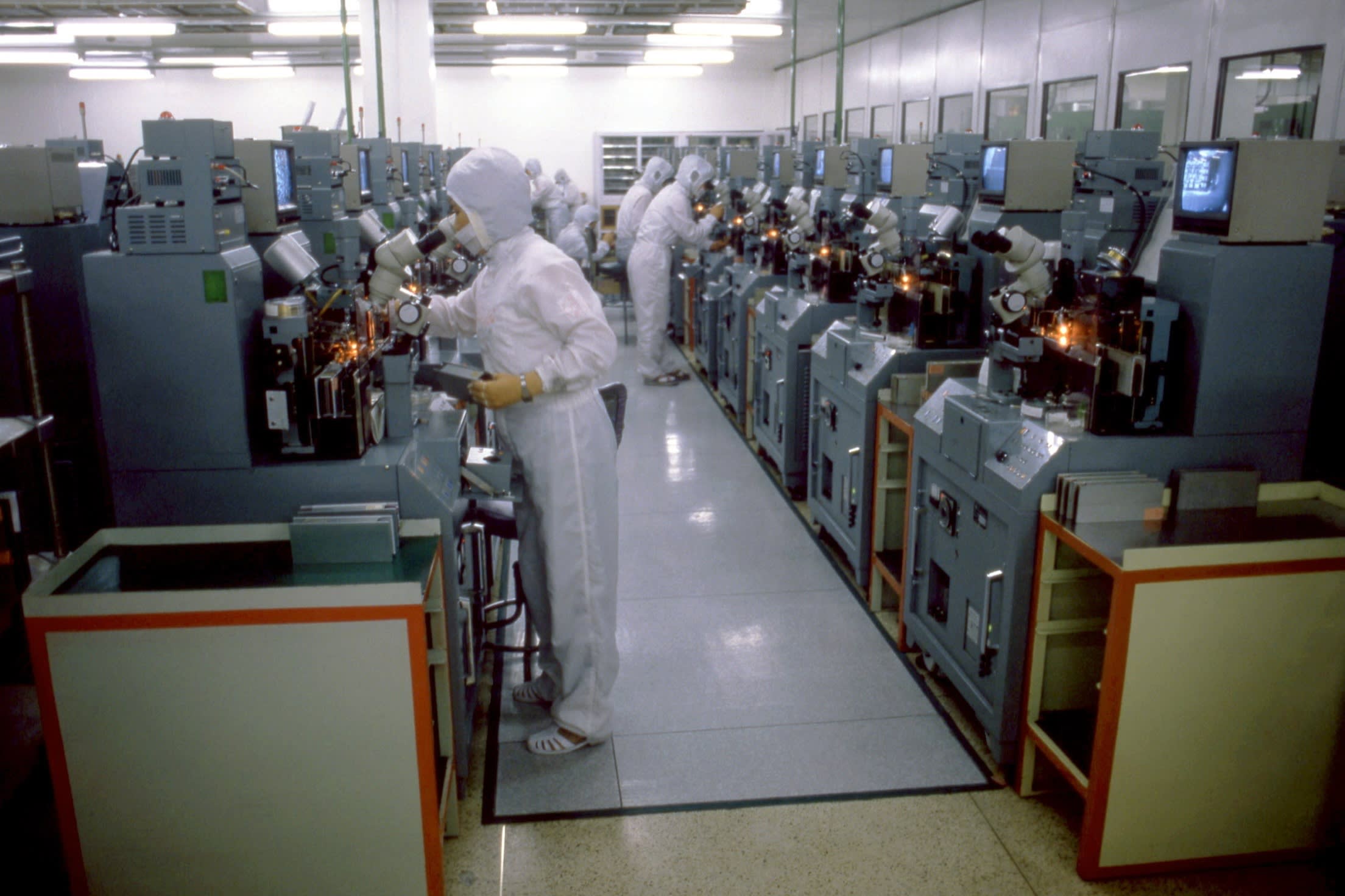 Goldstar Electronic manufacturing workers wearing special suits and masks as they test electronic equipment in 1987 in Busan, South Korea