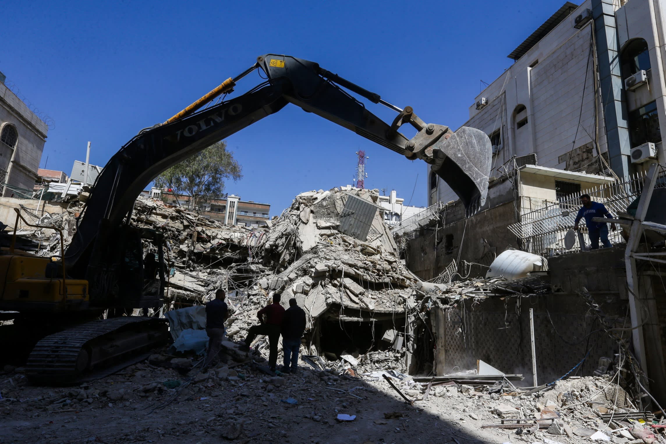 Rescue workers search in the rubble of a building annexed to the Iranian embassy a day after an air strike in Damascus