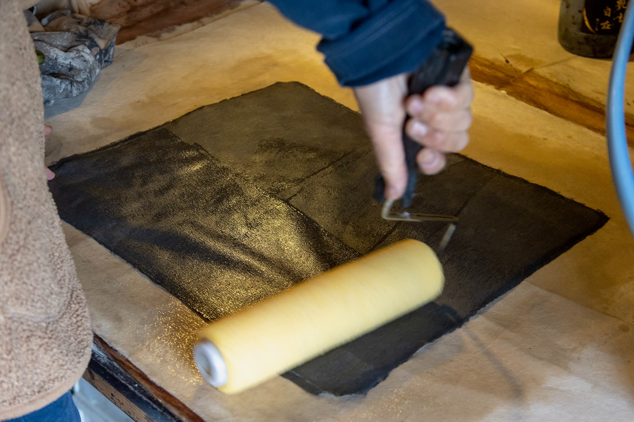 Hatano’s wife applies konnyaku glue to a sheet of washi