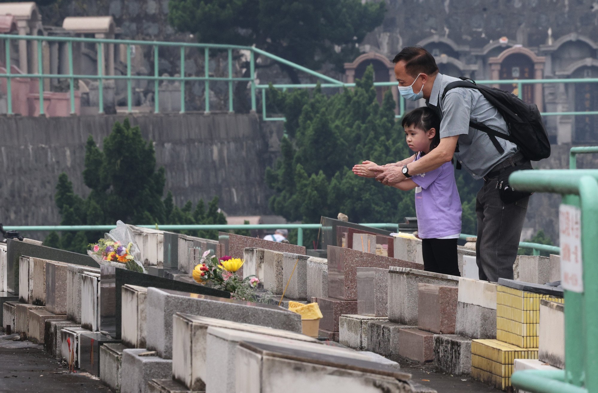 A man and a child offer prayers at the grave of a deceased loved one at a cemetery in Hong Kong during the Ching Ming Festival on April 4. Photo: Jelly Tse