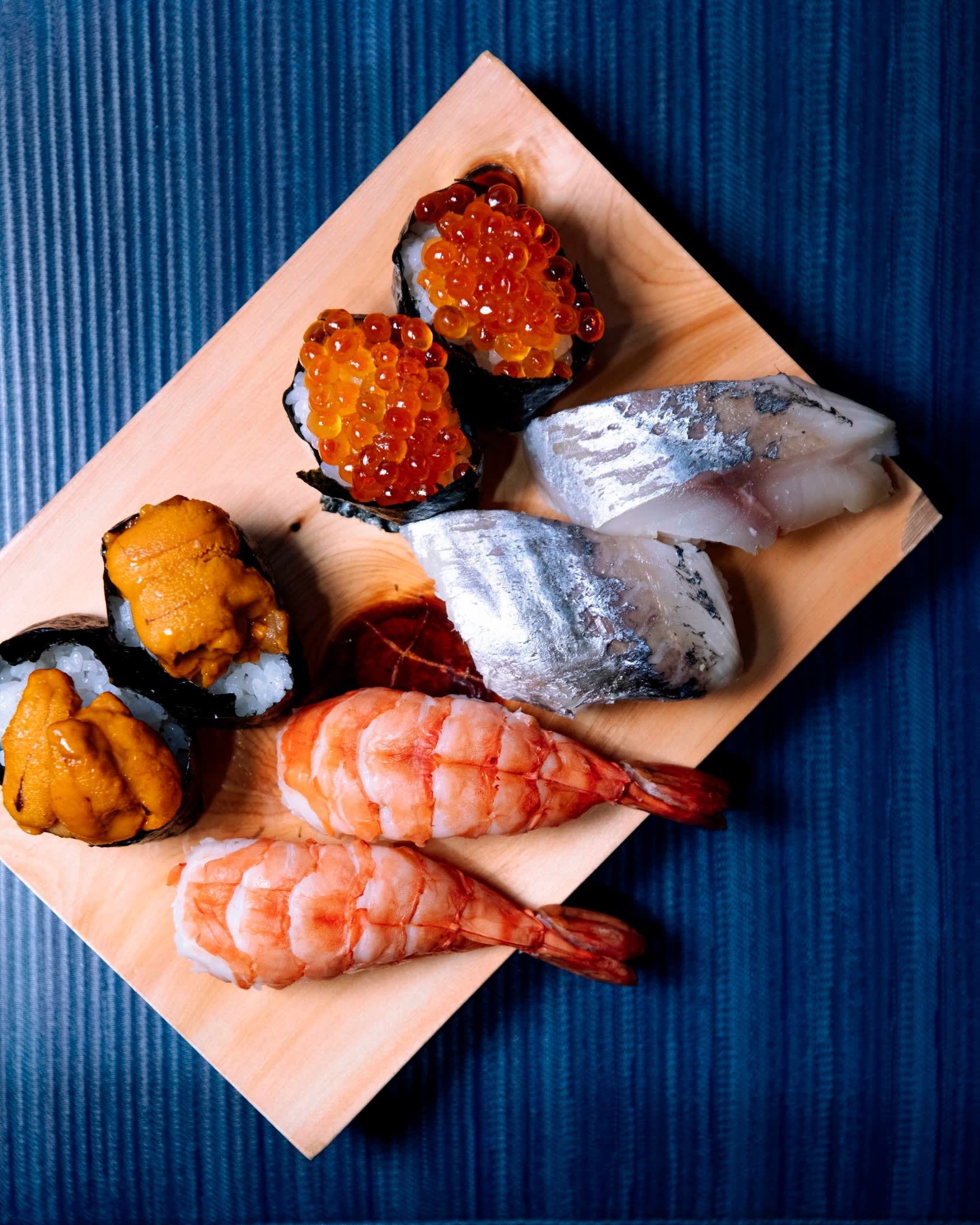 Eight pieces of sushi on a rectangular wooden tray at Wakana Sushi