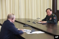 Russian President Vladimir Putin, left, speaks to General Zhang Youxia, vice chairman of China's Central Military Commission, during a meeting outside Moscow on Nov. 8, 2023. (Kremlin photo via AP)