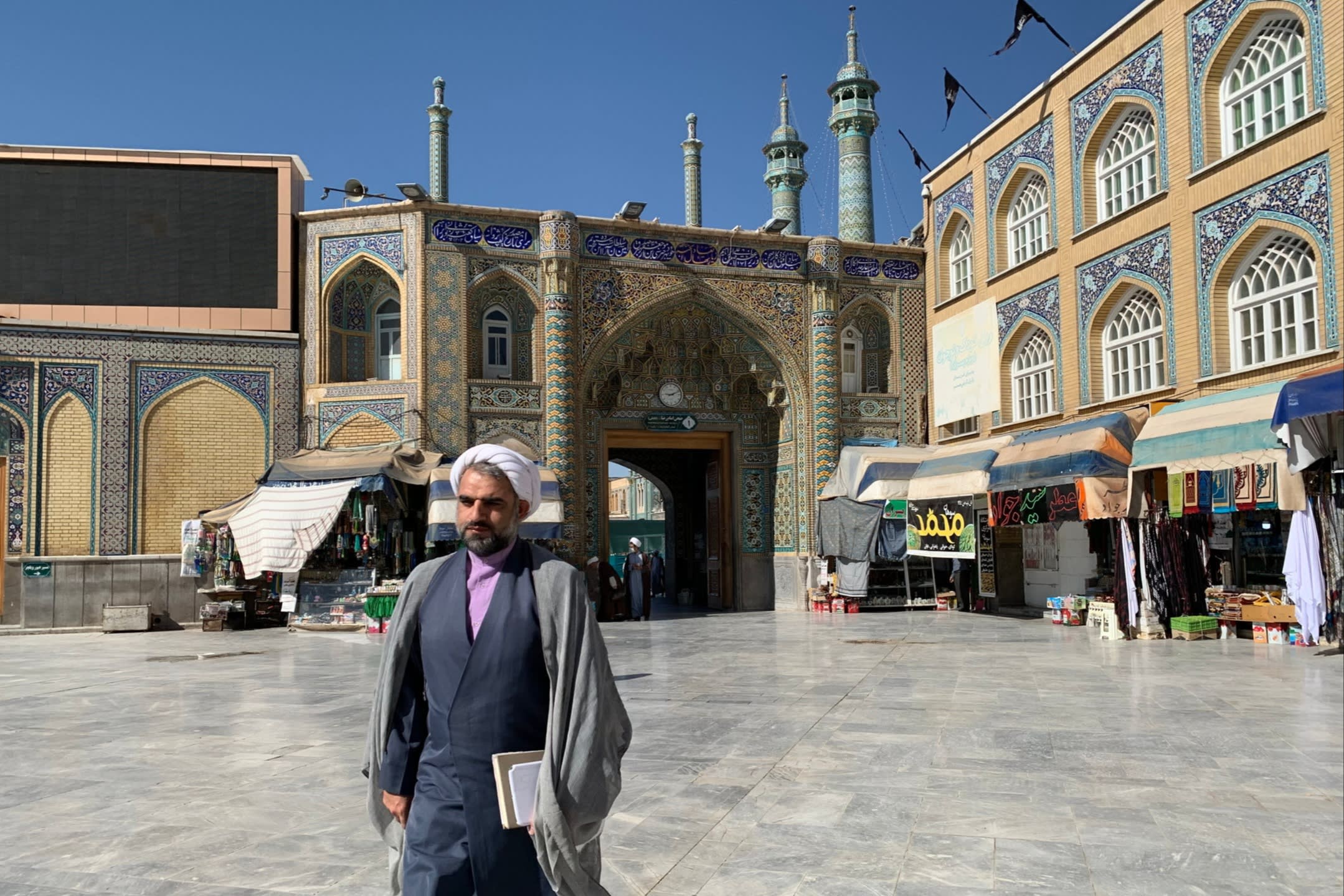 A cleric walking across a square in the holy city of Qom