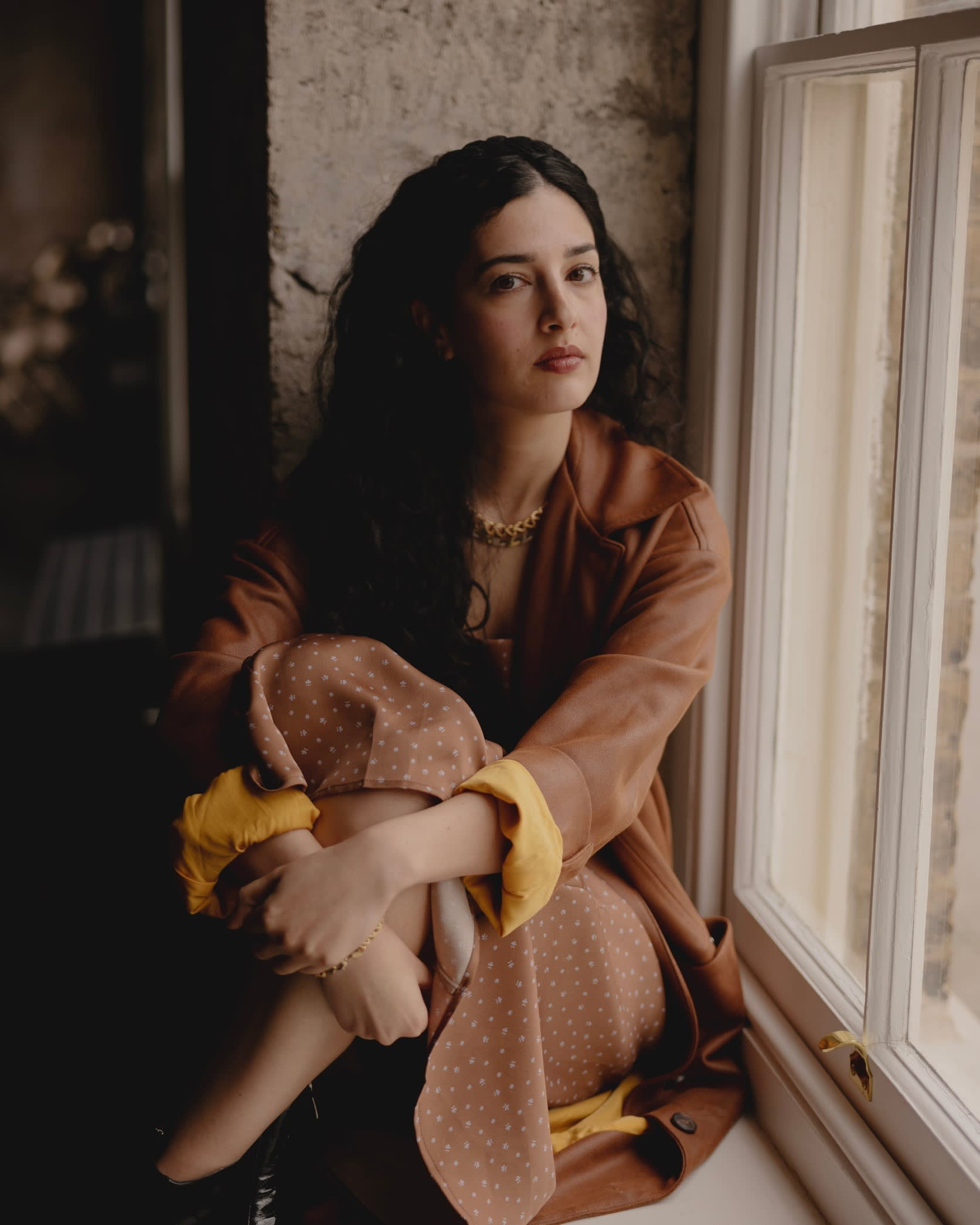 A woman sits on a window ledge