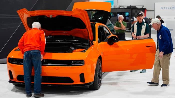 Shoppers look over a 2025 Dodge Charger Daytona hardtop in the Stellantis display at the Colorado Auto Show