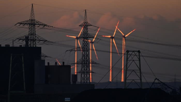 Wind turbines next to electricity pylons at ThyssenKrupp’s plant in Duisburg, western Germany