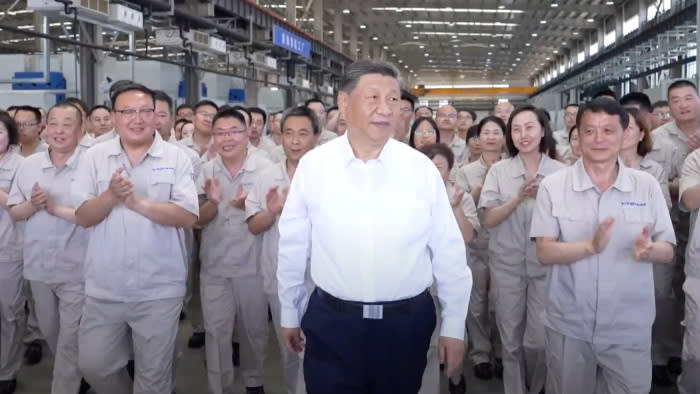 Chinese leader Xi Jinping visits a ballbearing factory in Luoyang, China on May 20 2025. He is surrounded by the plant’s staff who are clapping.