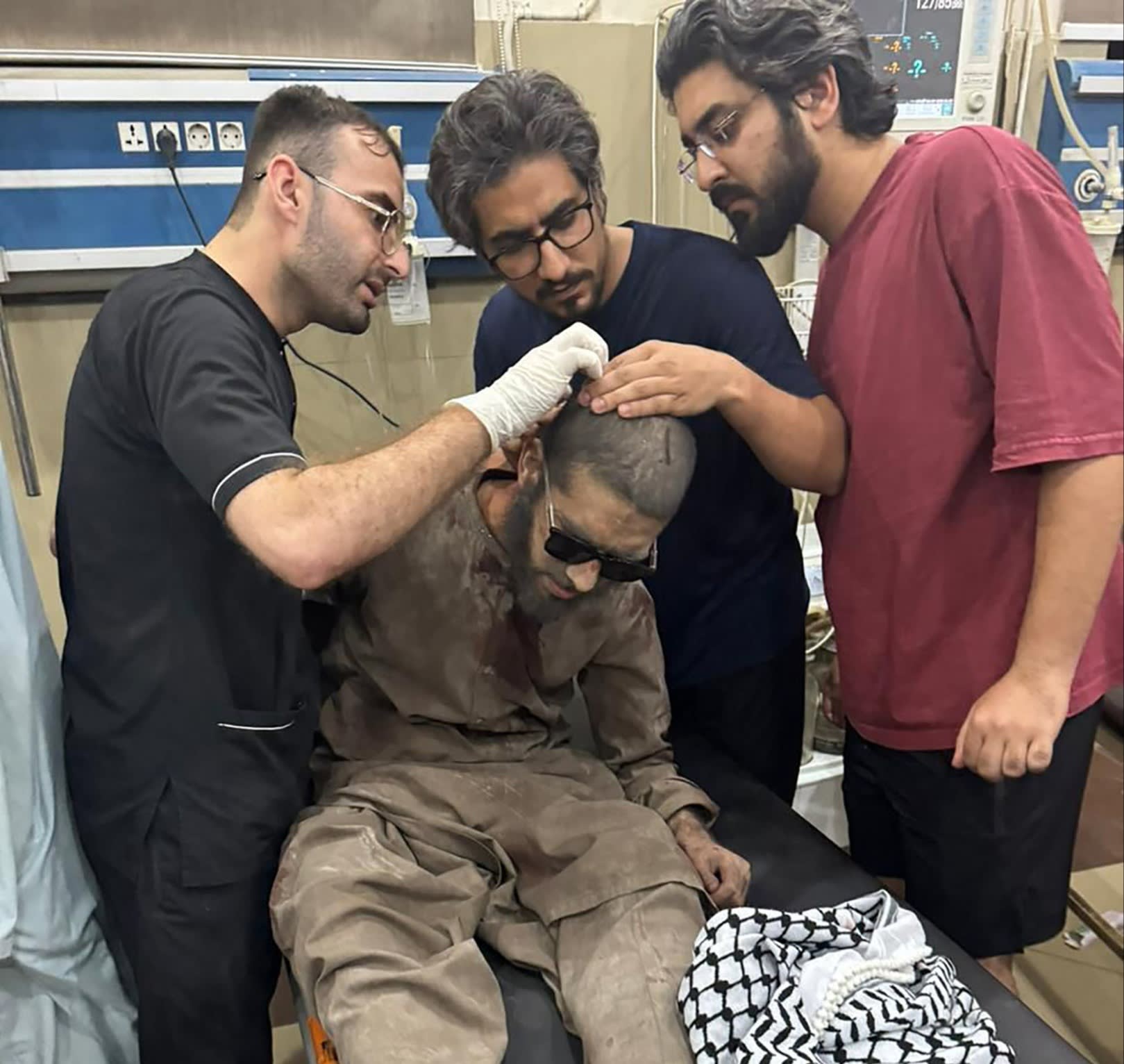 Paramedics giving treatment to an injured man at a hospital in Bahawalpur