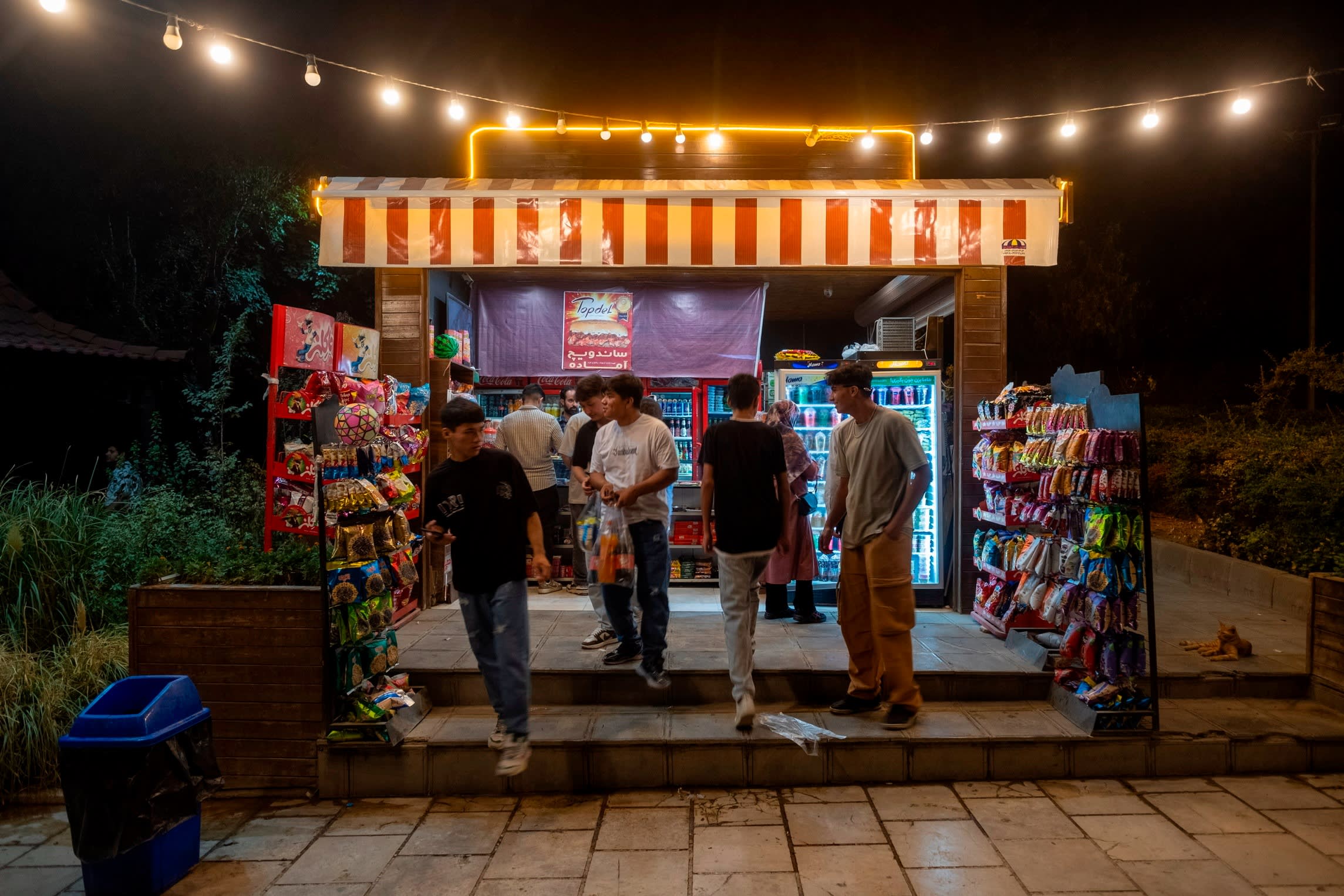 Young Afghan men at a snack stand in a park in Tehran, Iran 