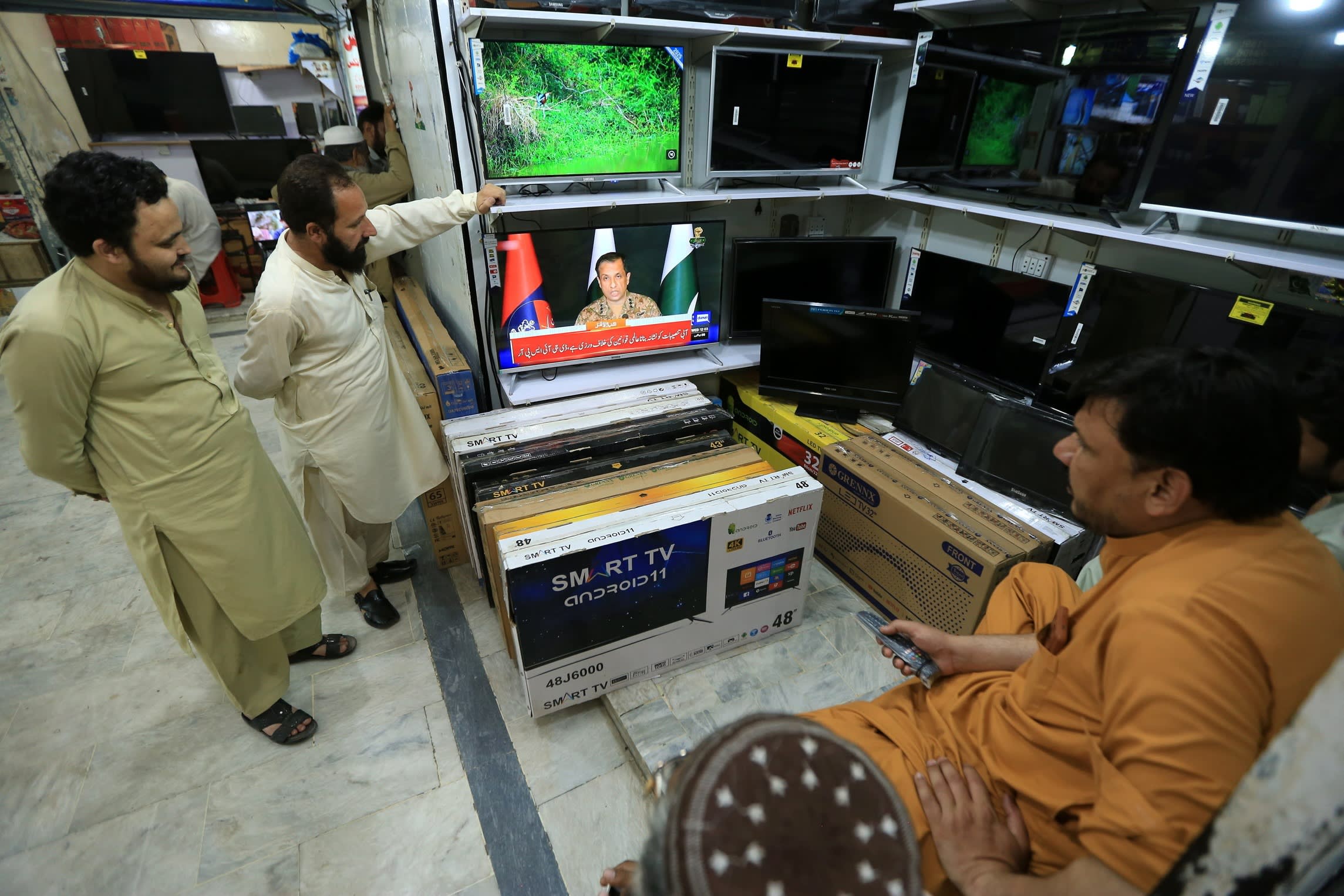 People watch TV reports of Indian missile strikes on Pakistan