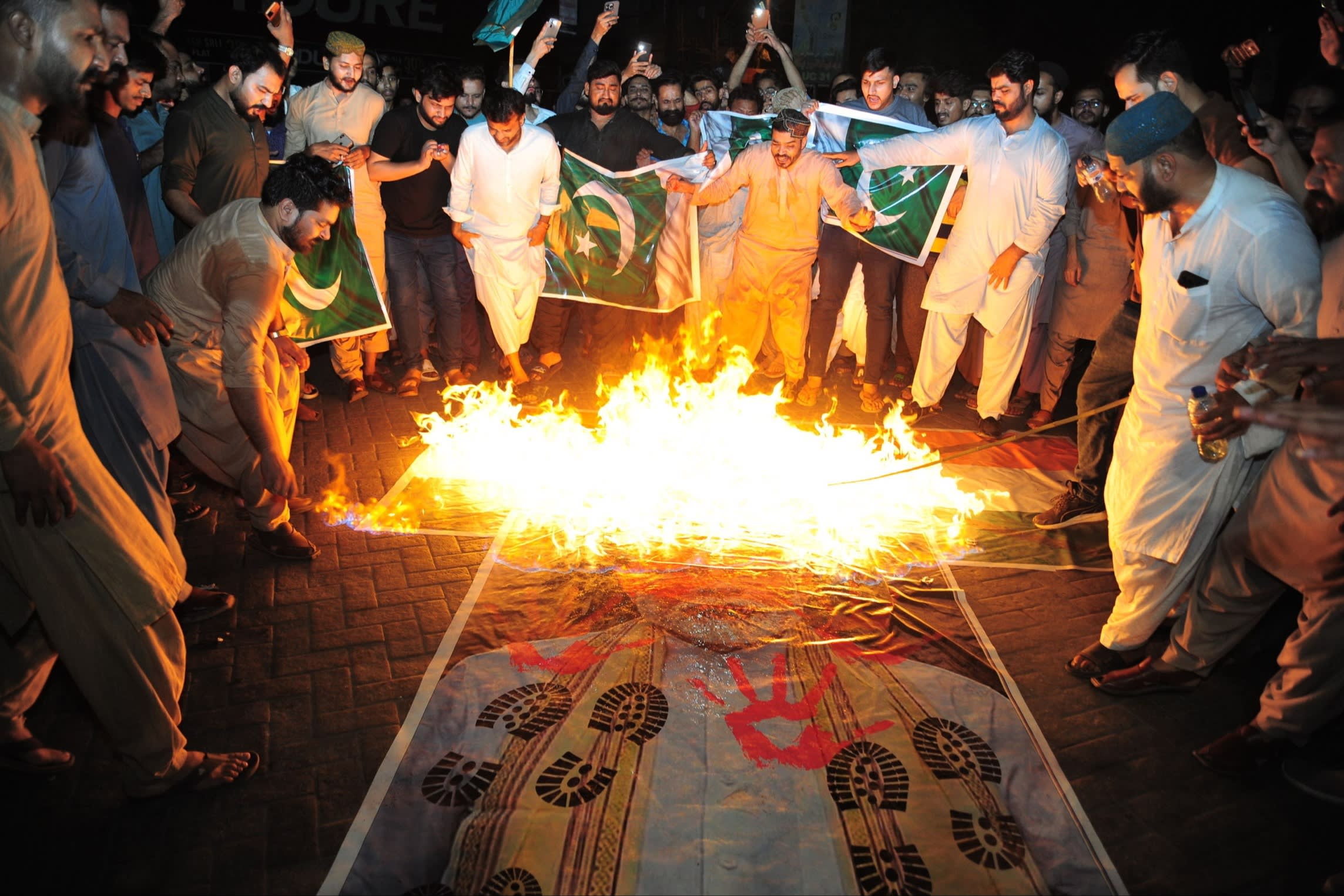 People burn a portrait of Indian Prime Minister Narendra Modi after India launched missile strikes in Pakistan, in Hyderabad,