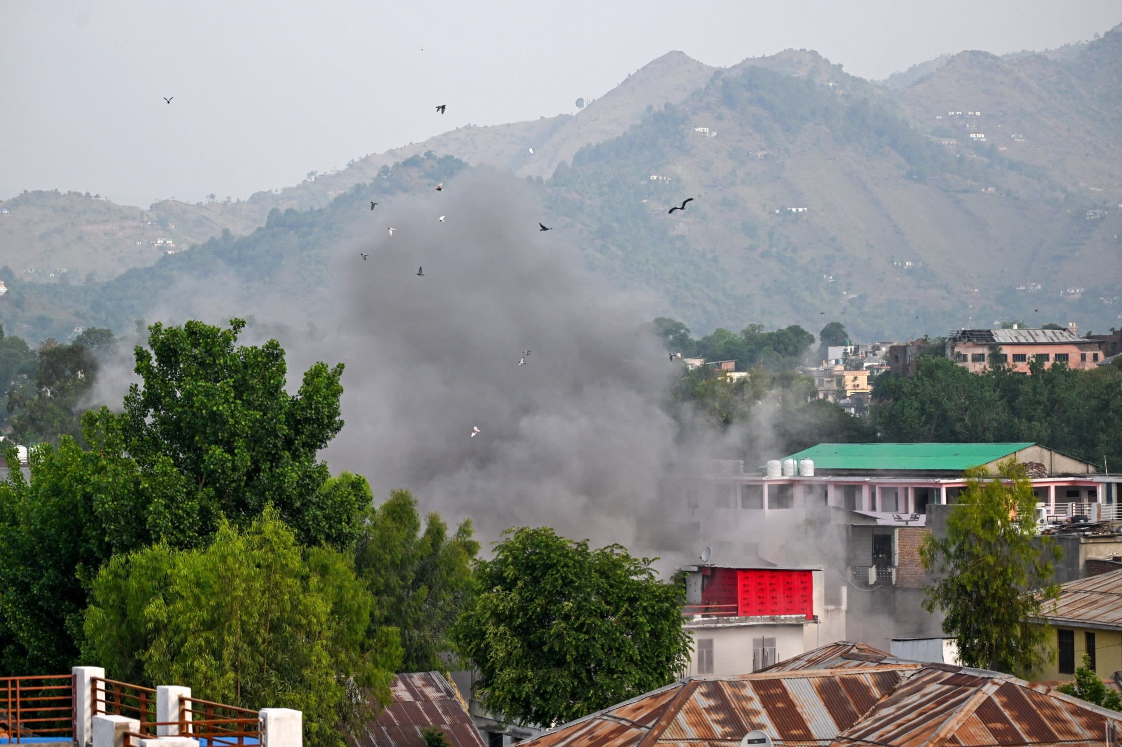 Smoke billows after an artillery shell landed in the main town of Poonch district