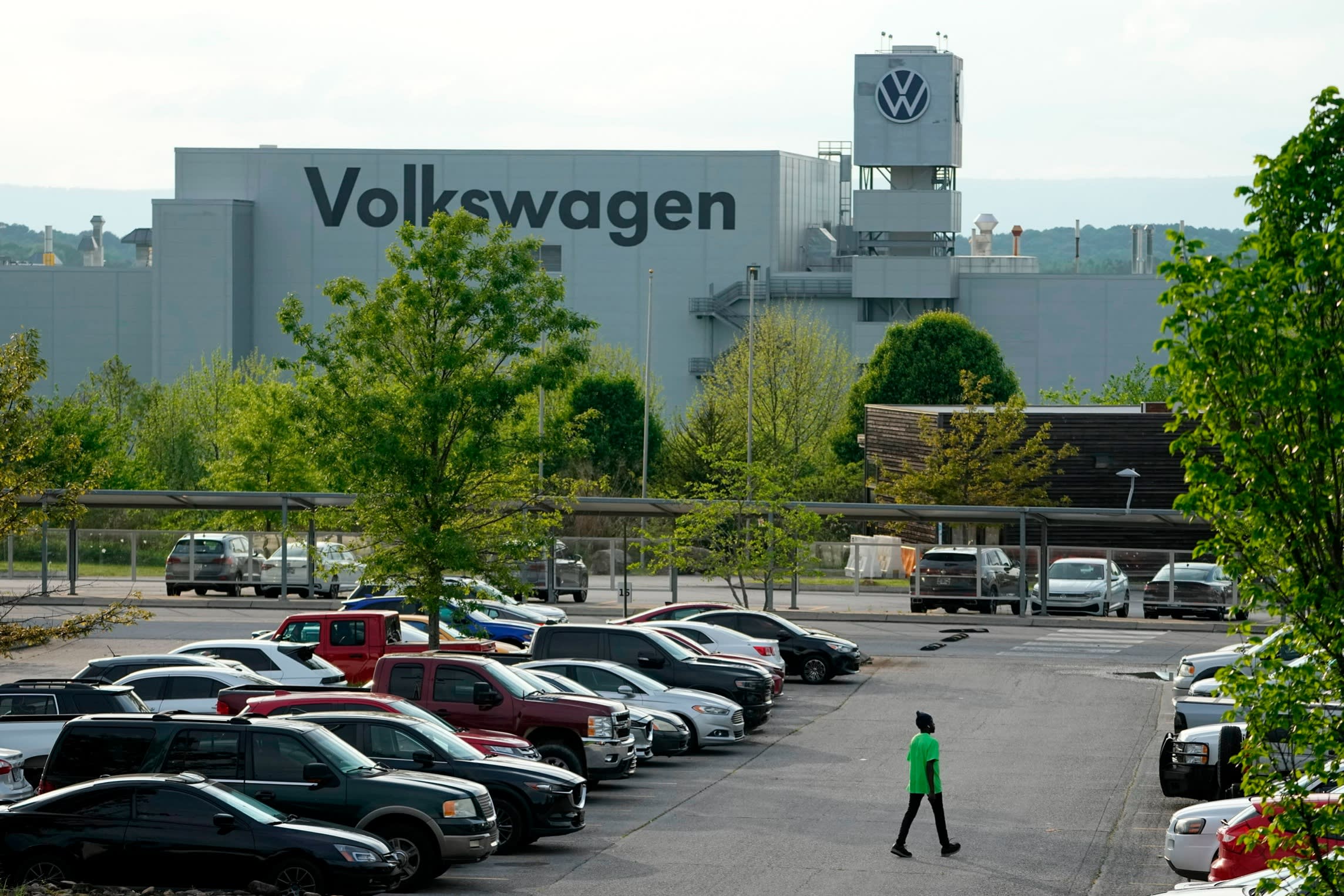 A person walks across the parking lot at the Volkswagen automobile plant