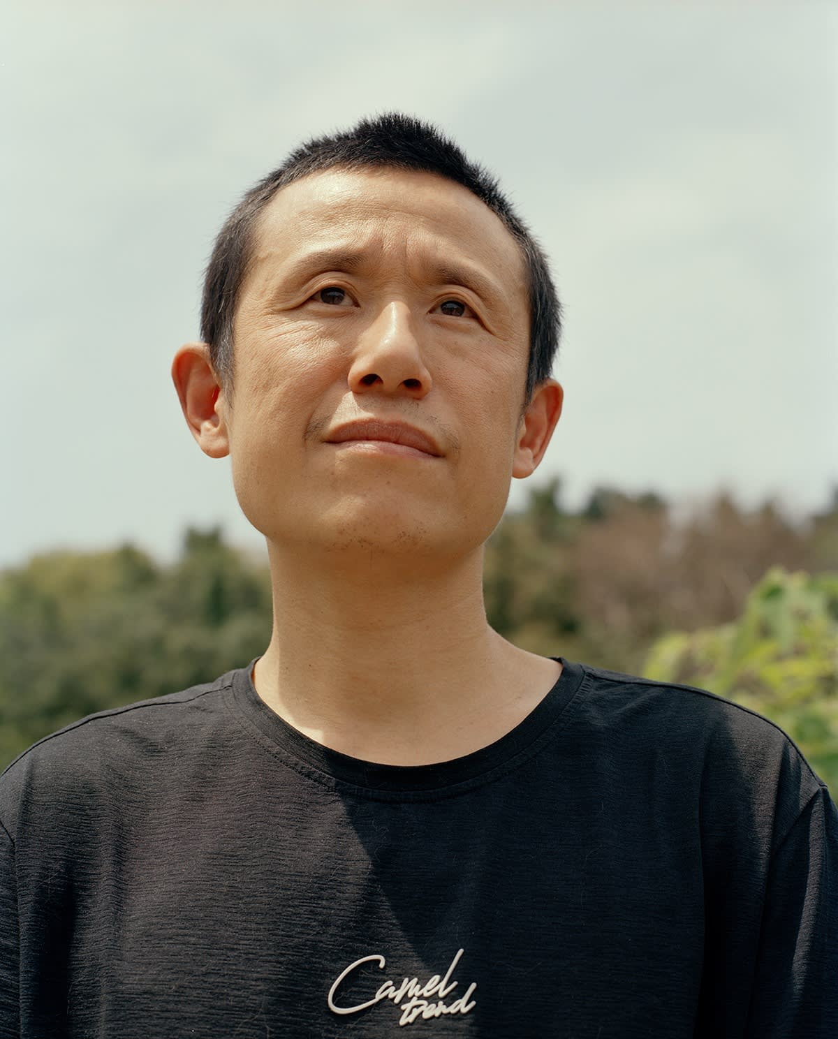 Close-up portrait of a man looking up outdoors