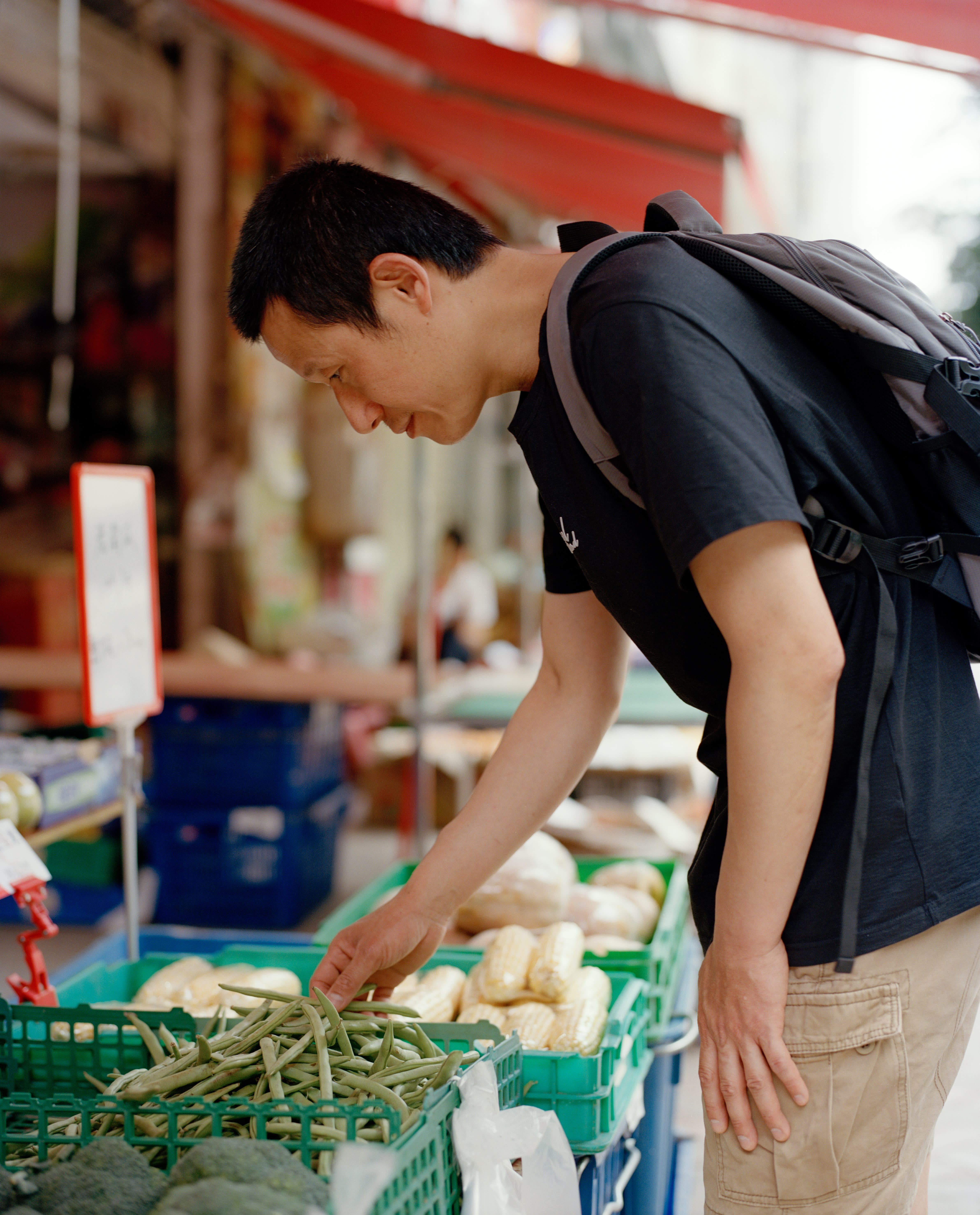 A man shops for vegetables at an outdoor market