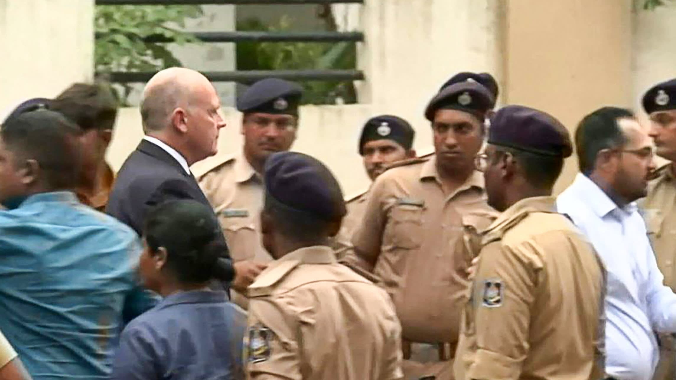 Campbell Wilson is surrounded by police officers and other officials