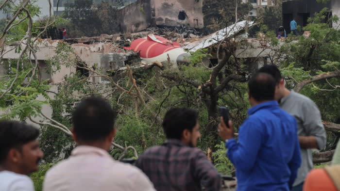People looking at the remnants of the Boeing 787-8 after it crashed into a student hostel in Ahmedabad