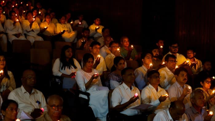 People hold candles as they take part in a special prayer ceremony