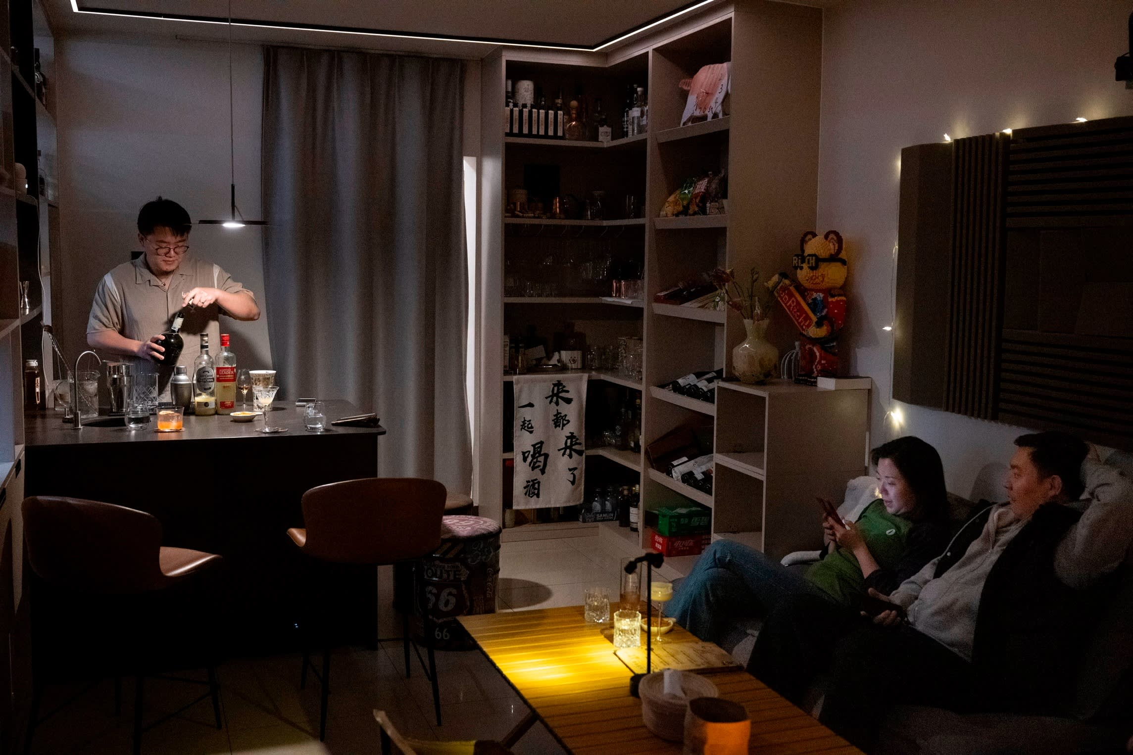 Yang behind a small bar in the apartment