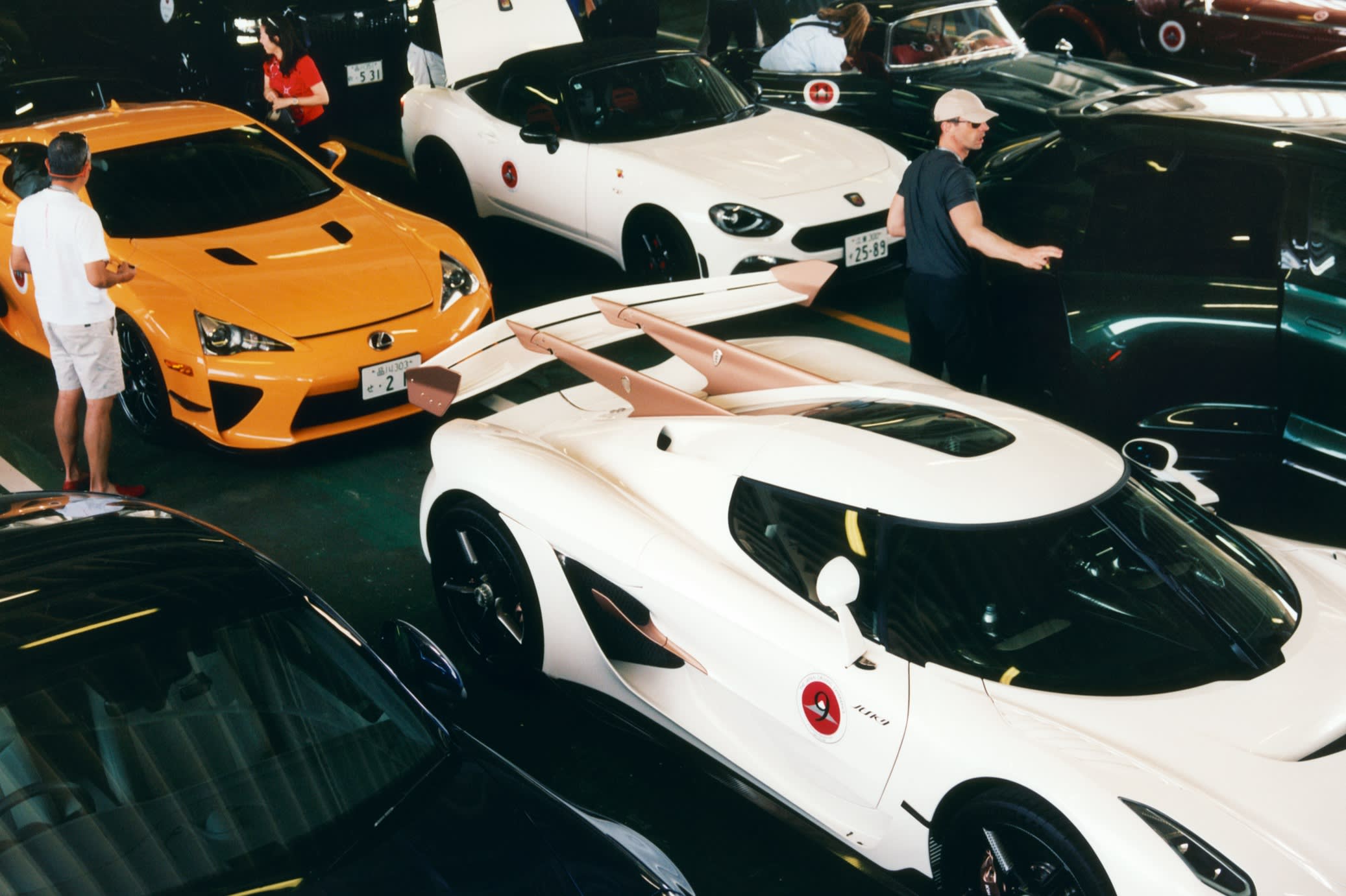 Cars (clockwise from top left) including the Lexus LFA, an Abarth 124 Spider, Mercedes-Benz 300 SL convertible, the author’s borrowed Aston Martin DBX707 and the Koenigsegg Agera, on the ferry across Tokyo Bay