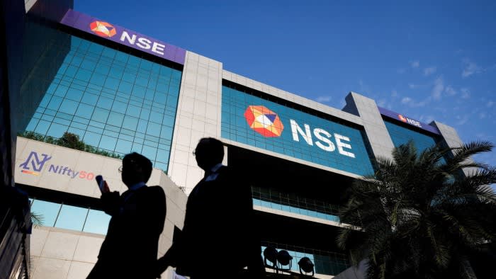 People walk outside the National Stock Exchange building in Mumbai