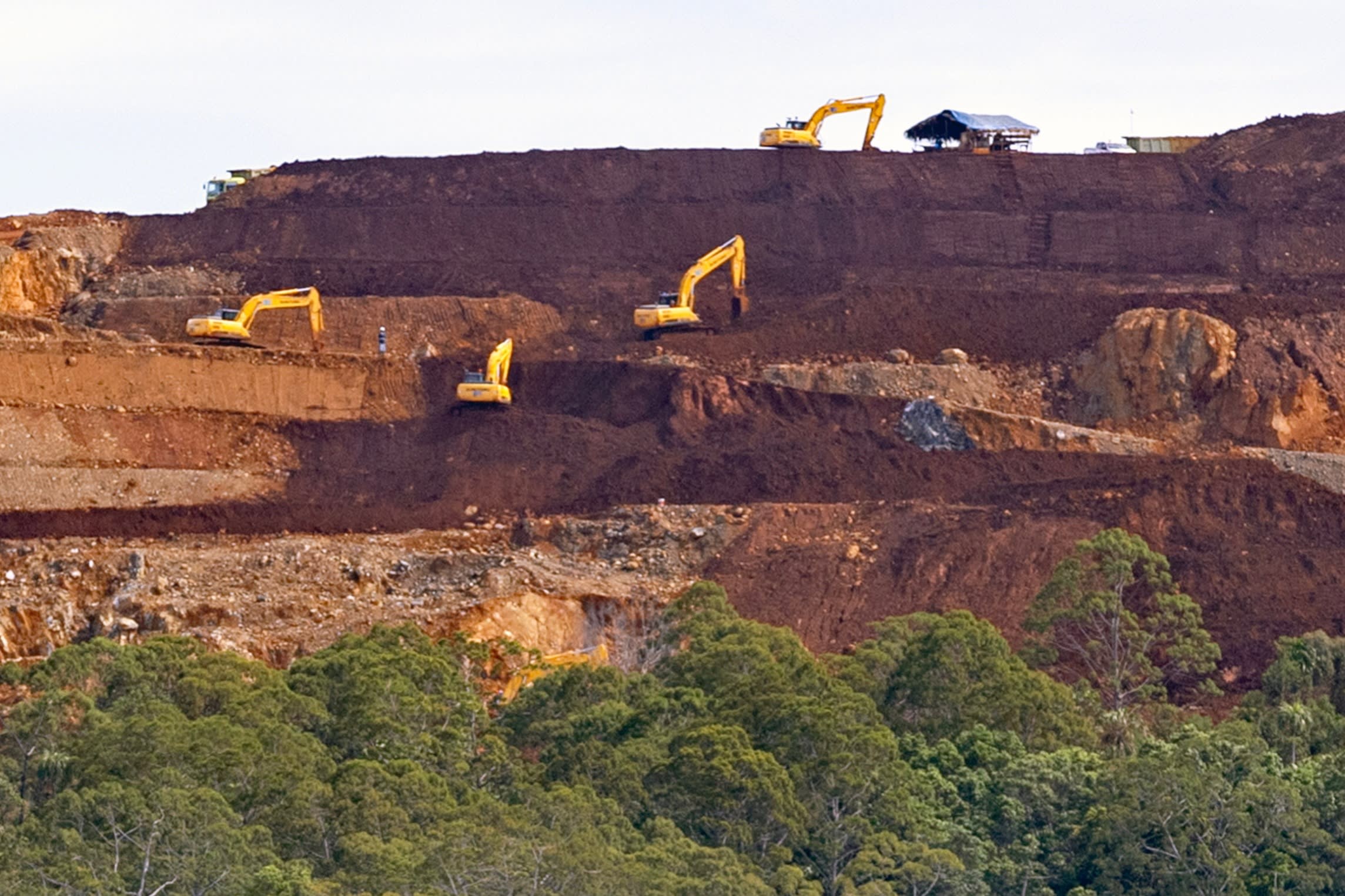 Heavy machinery operates at the nickel mining site of PT Kawei Sejahtera Mining on Kawe Island