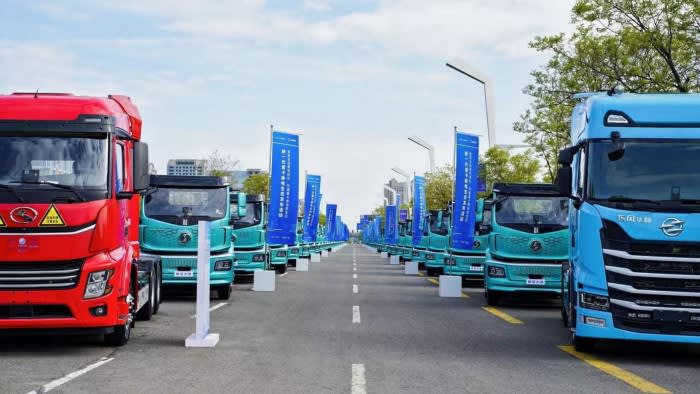 Two long rows of Chinese trucks on a road