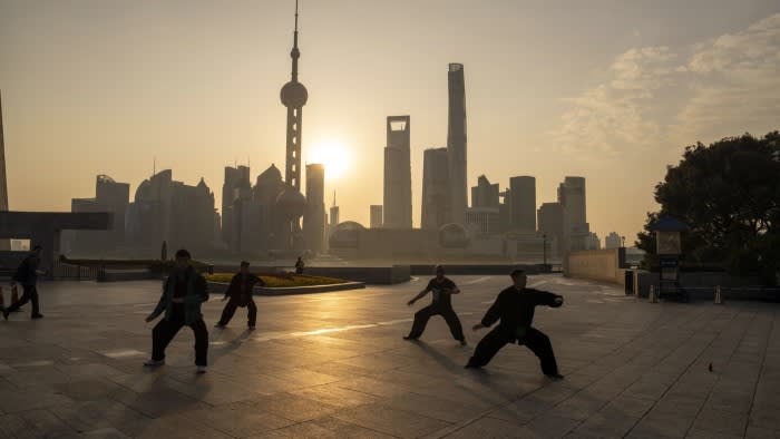 People practise tai chi in front of buildings in Pudong’s Lujiazui financial district in Shanghai, China