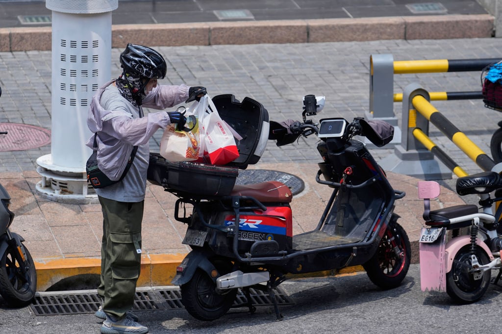 An online food delivery rider sorts out orders in Beijing on July 11, 2025. Photo: AP