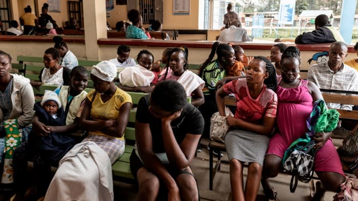 A group of mothers gather with their children at a medical facility in Kenya that was once supported by US aid