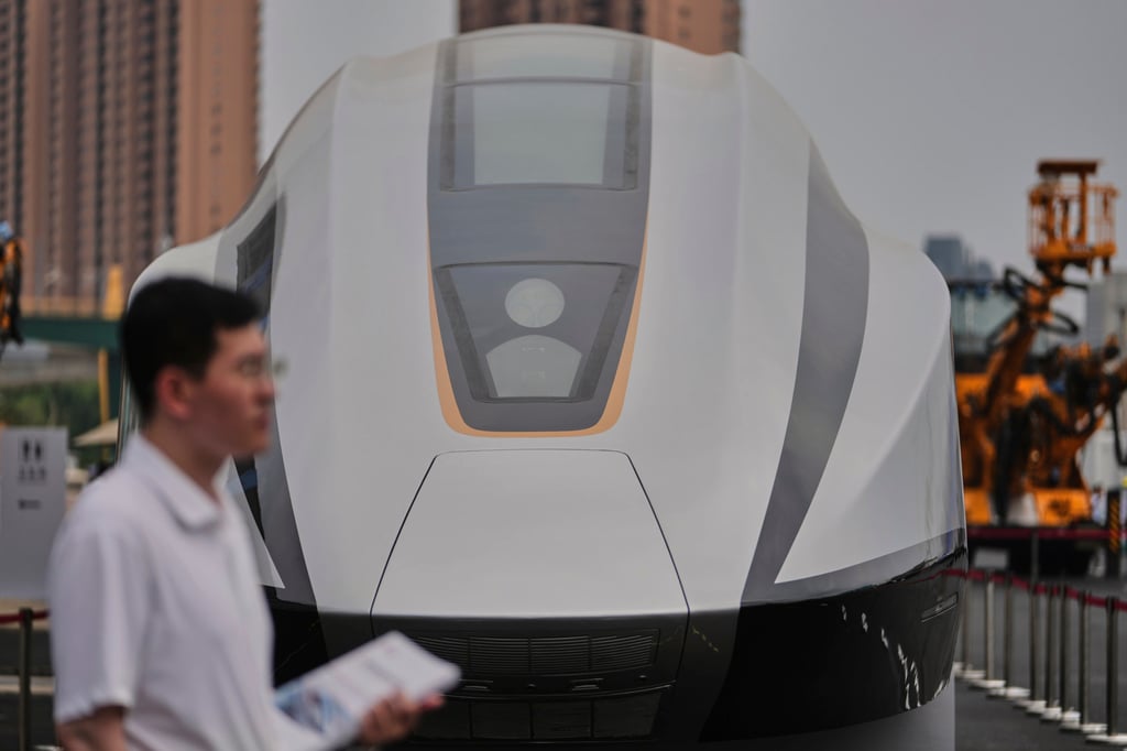 A volunteer holds leaflets as he stands near a 600km High Speed Maglev model showcasing at the National Railway Test Center during a tour by delegates to the World Congress on High-Speed Rail held in Beijing on July 9, 2025. Photo: AP A volunteer holds leaflets as he stands near a 600km High Speed Maglev model showcasing at the National Railway Test Center during a tour by delegates to the World Congress on High-Speed Rail held in Beijing on July 9, 2025. Photo: AP