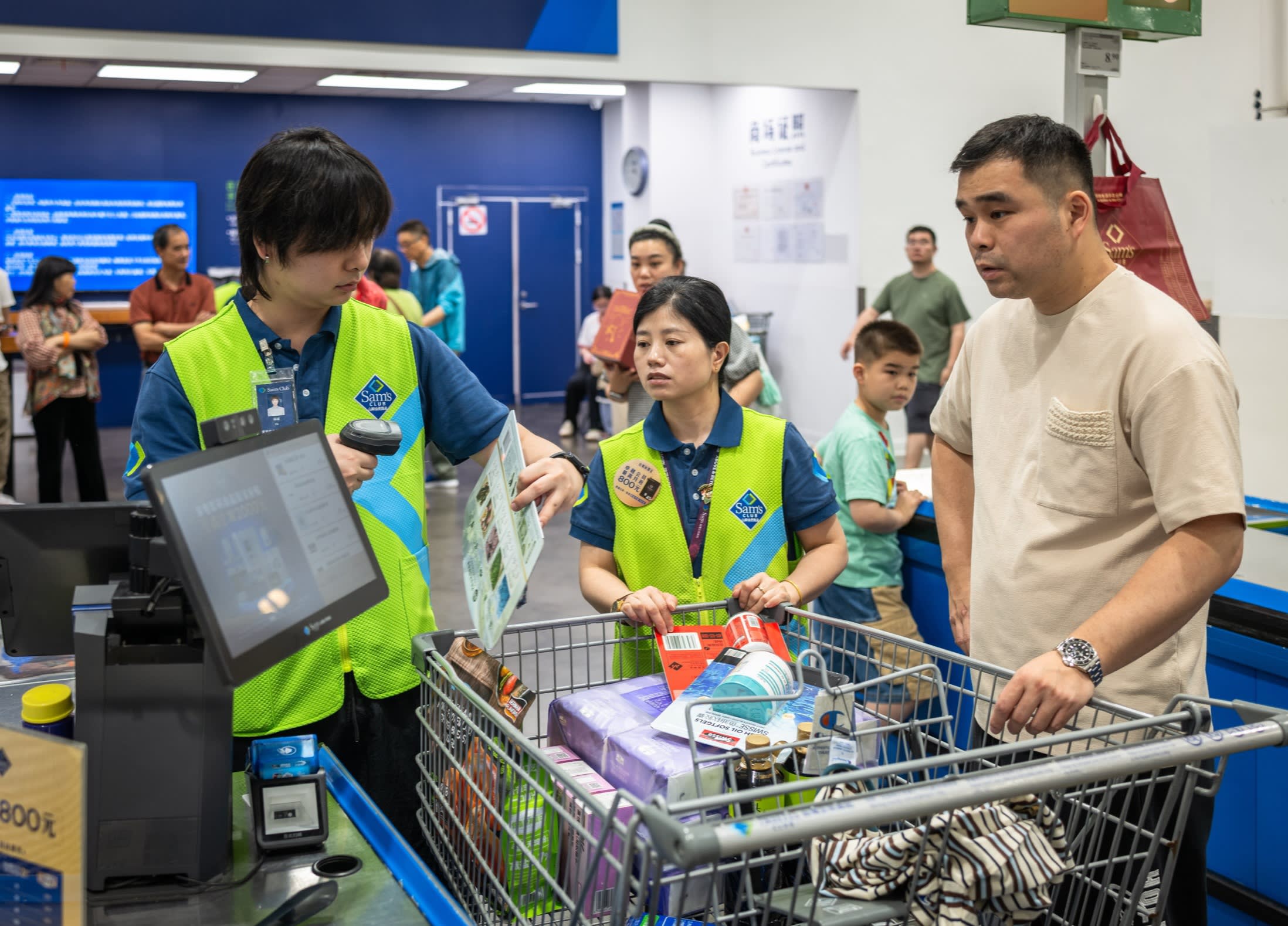 Staff scan items from a shopper’s trolley