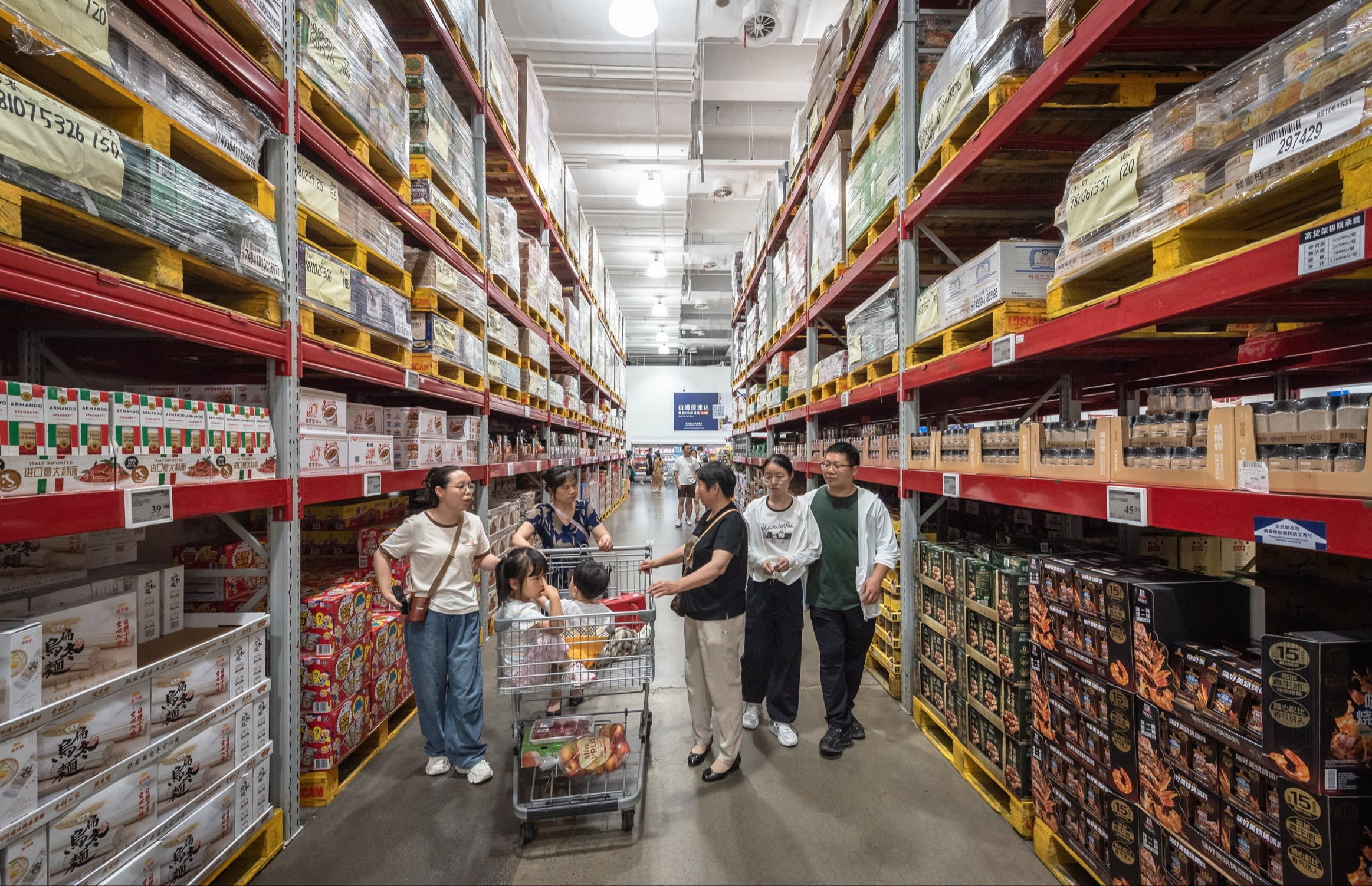 Children ride in a trolley as shoppers make there way down the aisles