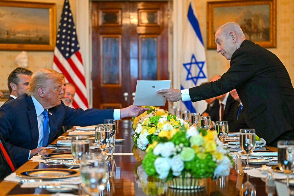 Israeli Prime Minister Benjamin Netanyahu (right) hands over a letter to US President Donald Trump at the White House on Monday. Photo: AFP