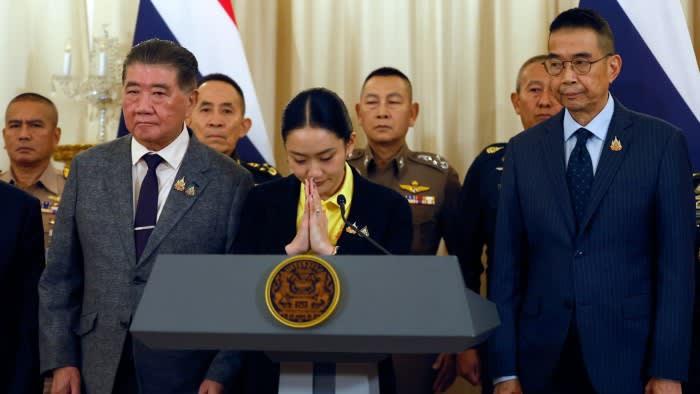 Thailand’s Prime Minister Paetongtarn Shinawatra, centre, apologises at a press conference surrounded by senior government and military officials