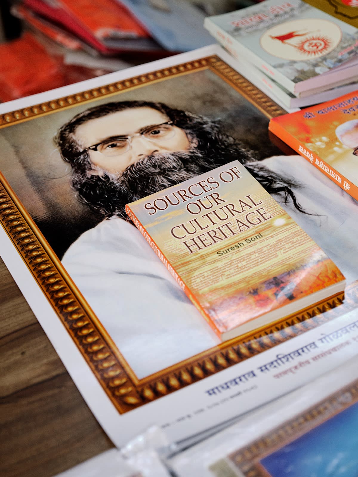 Portrait of a man with long hair and a long beard wearing glasses under a book