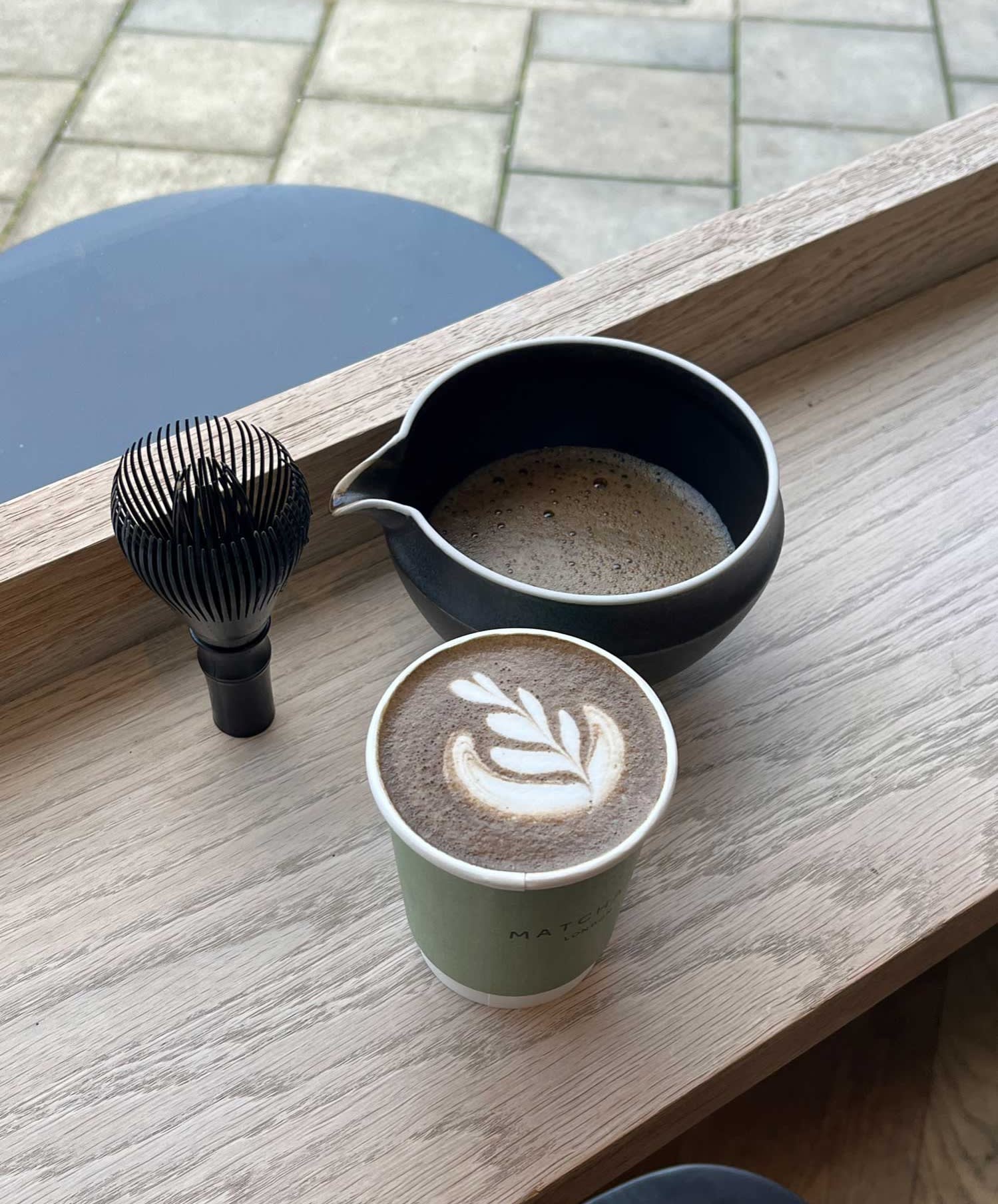 A hojicha latte with a bowl and whisk at Matchado in north London