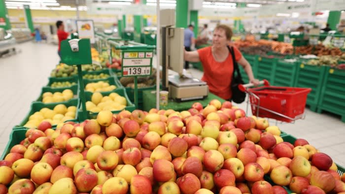 A customer weighs apples in a supermarket in Moscow