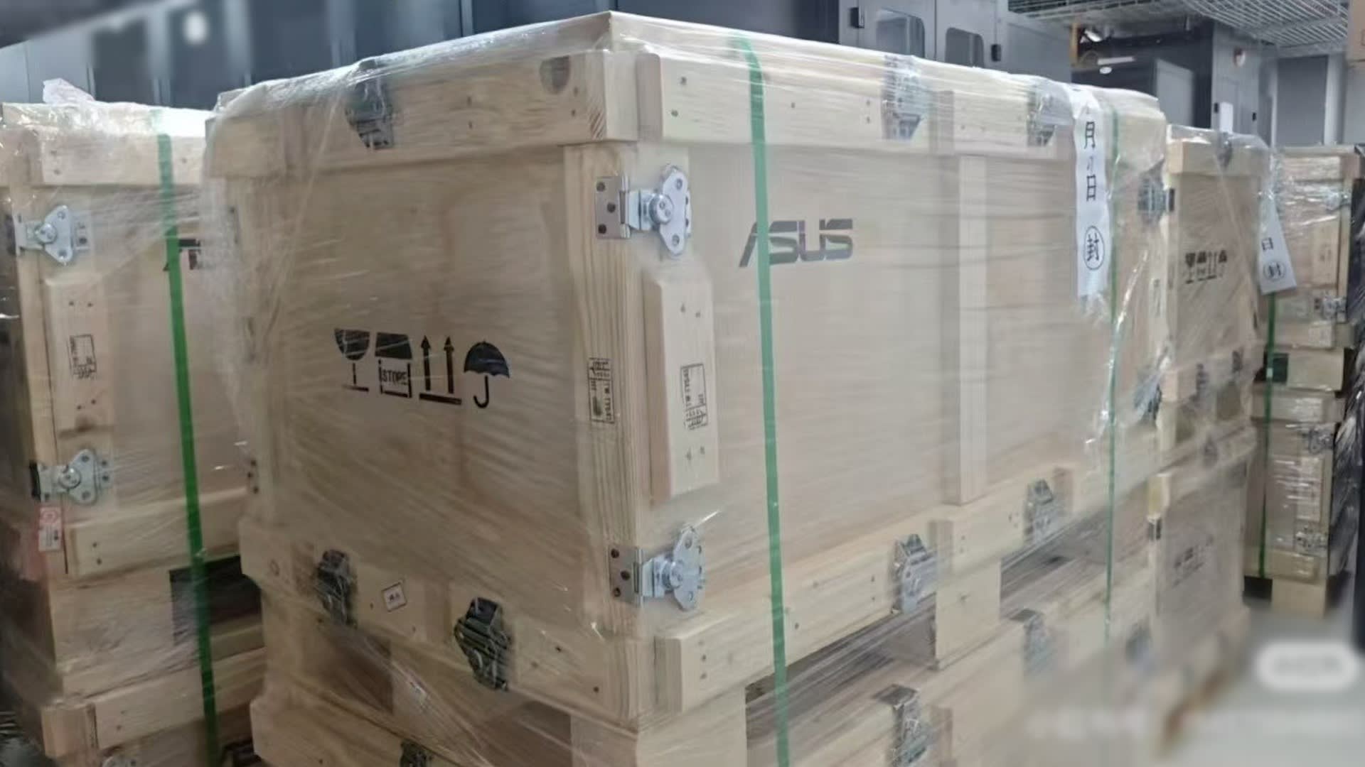 Eight large wooden boxes. The Asus logo is clearly visible on the nearest box